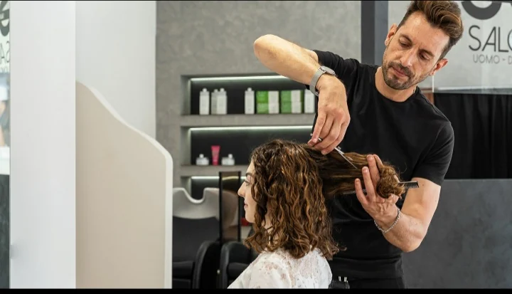 Giuseppe mentre taglia i capelli nel salone